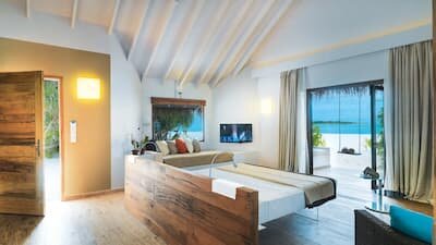 LAGO-designed villa interior at Cocoon Maldives with a floating bed and wildwood table